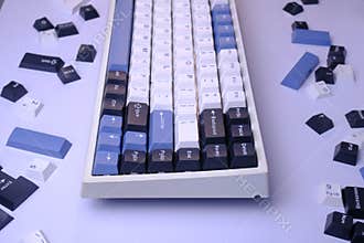 Close Up Modern 75% Layout Mechanical Keyboard with White, Blue, and Black Keycaps on a Clean White Desk