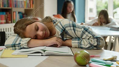 Tired exhausted kid schoolgirl teen Caucasian child daughter girl pupil school student sleeping desk books boring