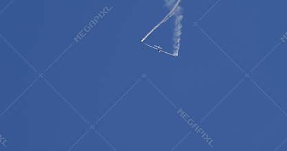 Extreme Glider Aerobatics with Smoke Trails in Clear Blue Sky