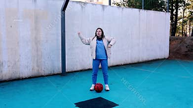 Girl practices soccer skills on an outdoor court in the early morning light