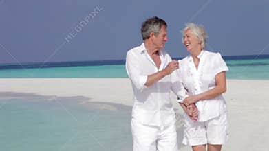 Senior Couple Walking On Beautiful Beach