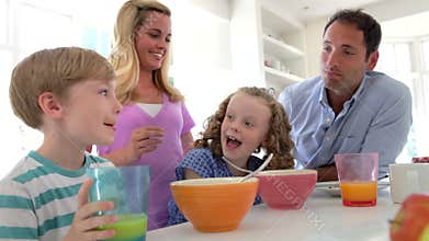 Family Having Breakfast In Kitchen Together