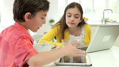 Children With Digital Tablet And Laptop At Breakfast