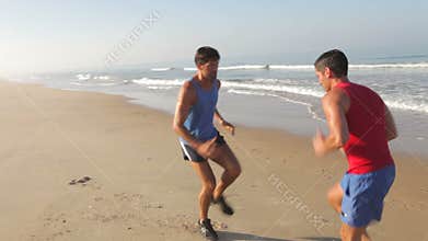 Two Men Working Out On Beach Together