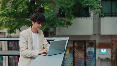 Focused man employee works on laptop put on parapet on office rest ground
