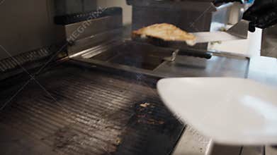 Chef Grabbing The Grilled Swordfish And Putting It In The Dish