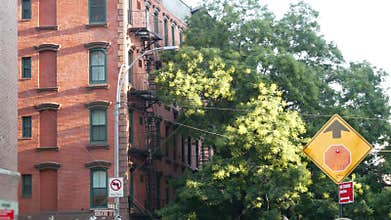 New York City building architecture, Manhattan. Residential house exterior. Red brick, fire escape.