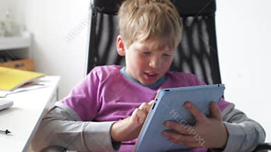 Boy Using Digital Tablet In Bedroom