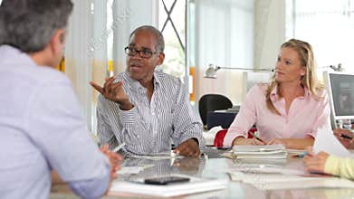 Team Meeting Around Table In Creative Office