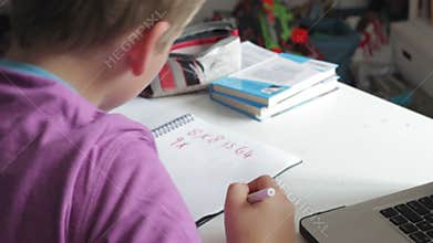 Boy Doing Math's Homework In Bedroom