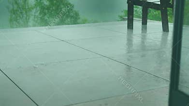 Rain Falling on Outdoor Patio with Chair
