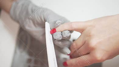 A woman shows off her red nails at a salon, highlighting selfcare