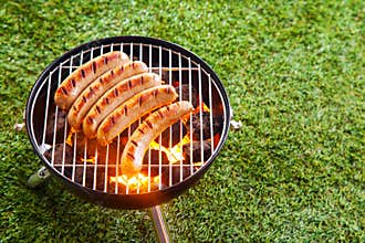 Sausages grilling on a portable barbecue
