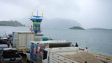 Krabi , Thailand , November 27, 2020 - Bustling on ferry loaded with trucks, cars, and passengers, crossing a misty to Lanta