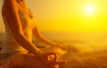 Hand of woman meditating in yoga pose on beach