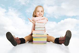 School girl and books stack. Smiling happy child pupil