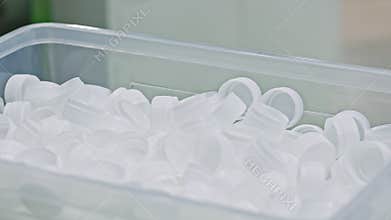 Plastic Caps in Industrial Bin at Packaging Factory