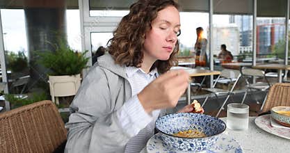 Woman is Joyfully Enjoying Delicious Meal at Contemporary Restaurant Featuring Stunning Scenic Views
