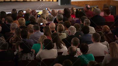 People seated in an audience and applauding