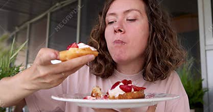 Woman enjoying delicious strawberry shortcake on a terrace