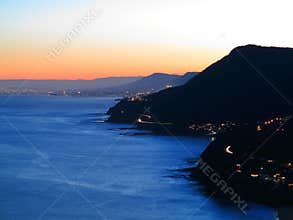 Scenic Australian coastline with lighted towns by dusk