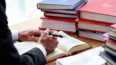 Author Signing Books at a Desk with Stacked Copies