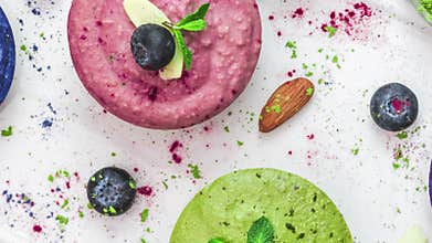 Healthy vegan cheesecakes. Assortment of colorful raw cashew cakes with matcha, acai, blueberry, mint and nuts. Gluten