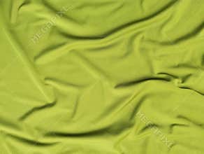 Abstrack green silk satin texture background. Beautiful wavy soft folds on the surface of the fabric.