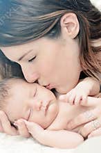 Mother kissing newborn baby