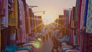 Vibrant Market Scene at Sunset with Colorful Fabrics and Local Vendors Footage