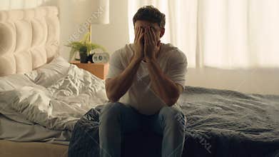 Caucasian man sitting on bed holding head grief pain crisis separation fatigue headache burnout bedroom guy male