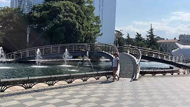 a woman walks along a fountain in Batumi, Georgia