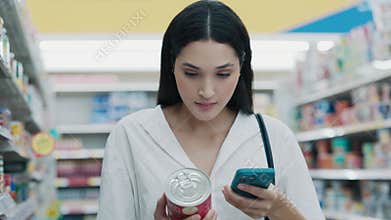 Dieting Female Standing and Examining Canned Product, Reading The Contents, Taking Note Of The Calories On Her