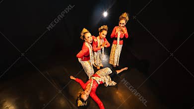 a group of traditional Javanese dancers wearing red costumes which provide a dramatic effect on the stage