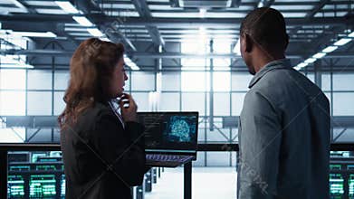 Programmers coding on laptop using artificial intelligence in server farm