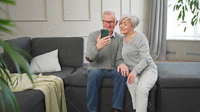 Video call. Happy senior couple woman man with smartphone having video call. Mature old grandmother grandfather talking