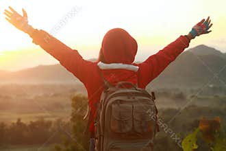 Happy woman spreading hands, mountain hiking