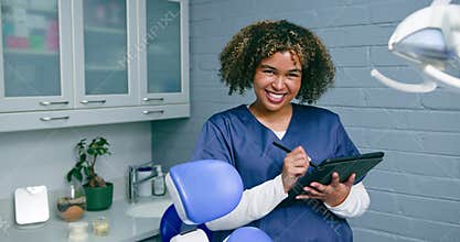 Smiling Dentist Using Tablet in Modern Dental Office: Managing Patient Information and Appointments with Technology