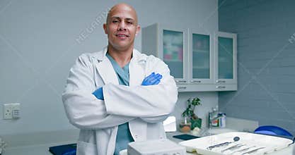 Confident Black Male Dentist Smiles with Arms Crossed in Modern Dental Office