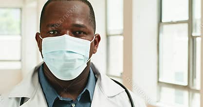 Portrait of Confident African American Male Doctor Wearing Face Mask in Hospital Corridor