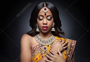 Young Indian woman in traditional clothing with bridal makeup and jewelry
