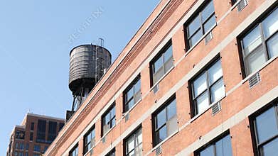 New York City industrial building exterior architecture, USA. Red brick facade. Rooftop water tower.
