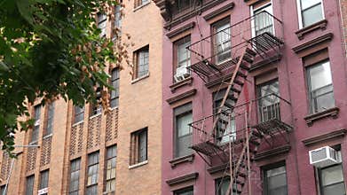 New York City building architecture, Manhattan. Residential house exterior. Red brick, fire escape.