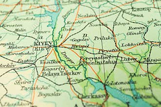 Round red thumb tack pinched through city of Kiev on Ukraine map. Part of collection covering all major capitals of