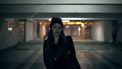 Girl teenager goes at night in the underpass