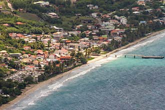 Aerial View of Coastal Le Diamant town with a Sandy Beach, Azure Ocean Waters, a Pier, and Colorful Houses on Lush Hills
