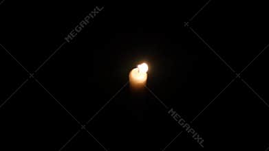 Hands holding a burning candle in dark