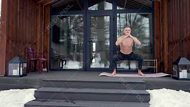 A man exercises on the terrace of his house.
