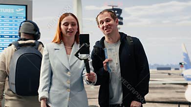 Influencers couple recording video blog in airport lounge area