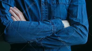 Casual confident man crossing arms in denim shirt